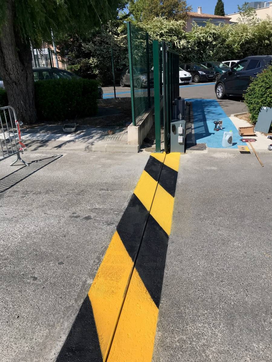 Marquage au sol par signalisation par bandes de peinture jaune et noire conforme aux normes CE en vigueur pour portail coulissant motorisé par Automatisations Services entre Marseille et Aix